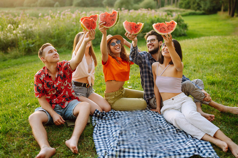 Gruppo di amici fanno un pic nic con il cocomero